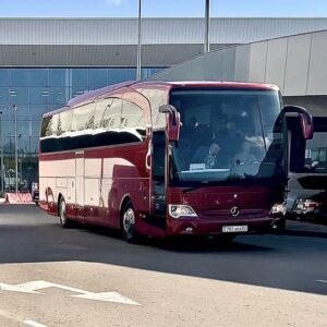 Красный туристический автобус Mercedes Travego в аэропорту Алматы